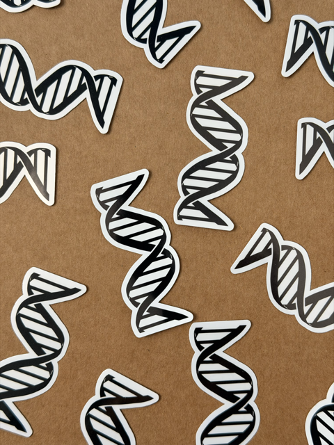 Unikalna kolekcja: Estetyczne naklejki naukowe przedstawiające eleganckie, czarne spiralne struktury DNA na organicznym, brązowym tle.